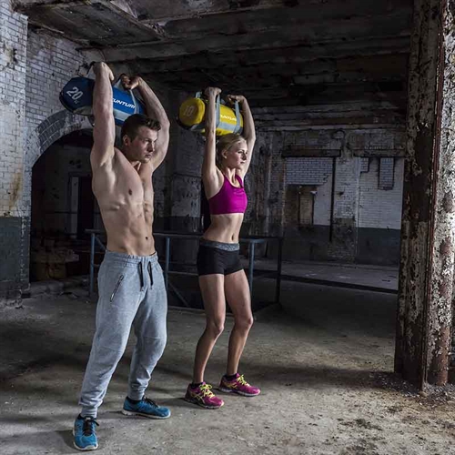 mand og kvinde træner med Tunturi Power Bag - 5kg