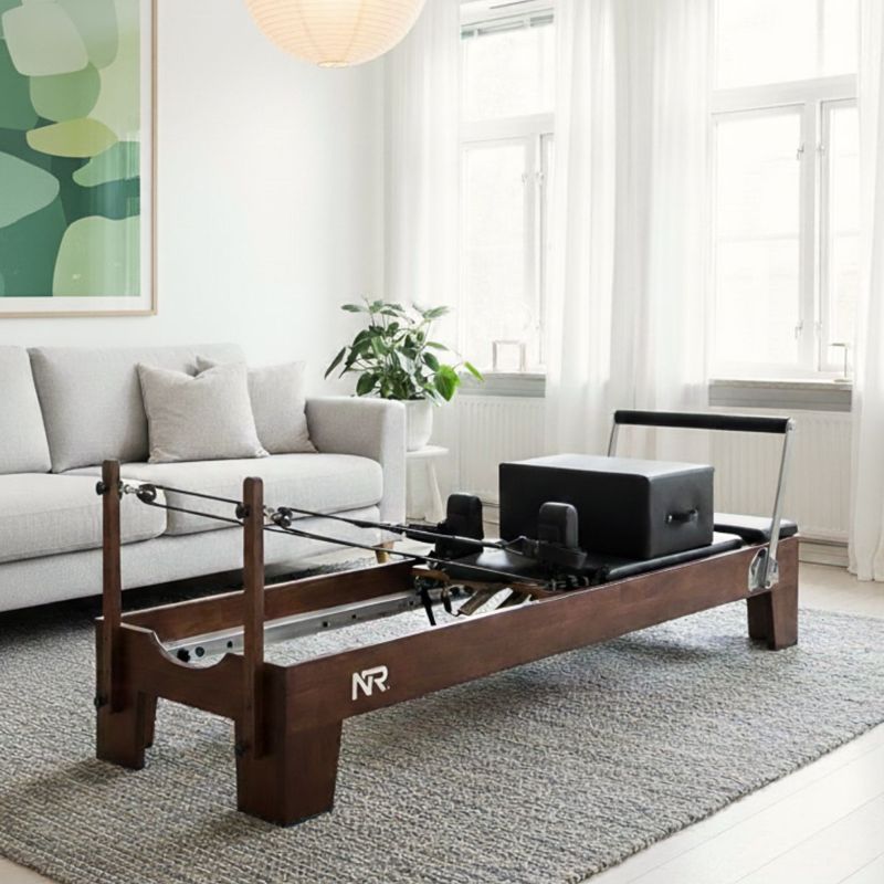 Reformer pilates maskine opstillet i stuen til hjemmetræning